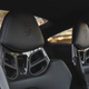 Black Porsche carbon fiber bucket seats with a Porsche crest embossed into the headrest.